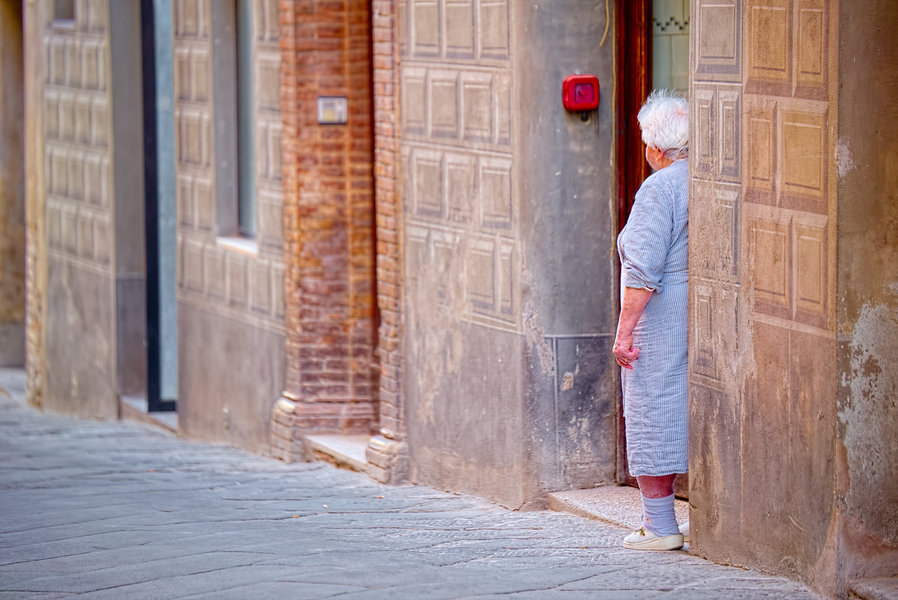 Toscane, lokale vrouw in haar deuropening